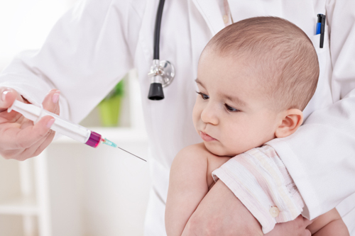 малышу делают прививку в руку