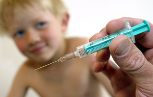 врач делает мальчику прививку