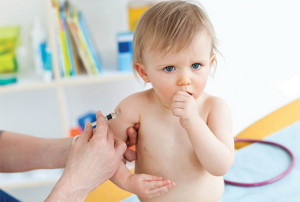 малышу делают прививку в руку