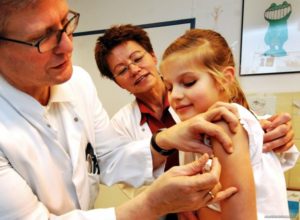 врач делает прививку девочке в руку