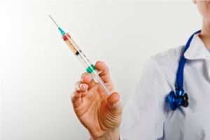 врач держит шприц с вакциной