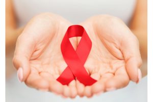 ленточка в форме значка СПИД на ладонях