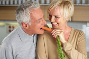 пожилой мужчина ест морковку