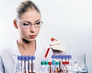лаборант смотрит пробирки с анализами крови