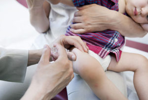 ребёнку делают прививку в бедро