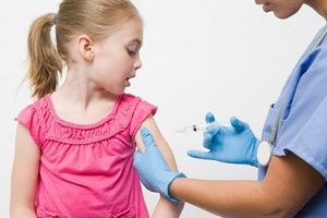 девочке врач ставит прививку в руку