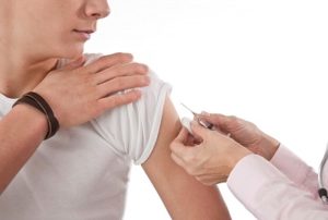 мужчине делают прививку в руку