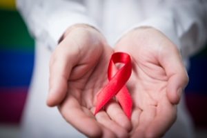 значок ВИЧ в руках человека